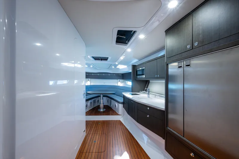 Karey Lee Yacht Photos Pics Luxurious interior of 2024 Intrepid 477 Evolution yacht with modern kitchen and seating area.
