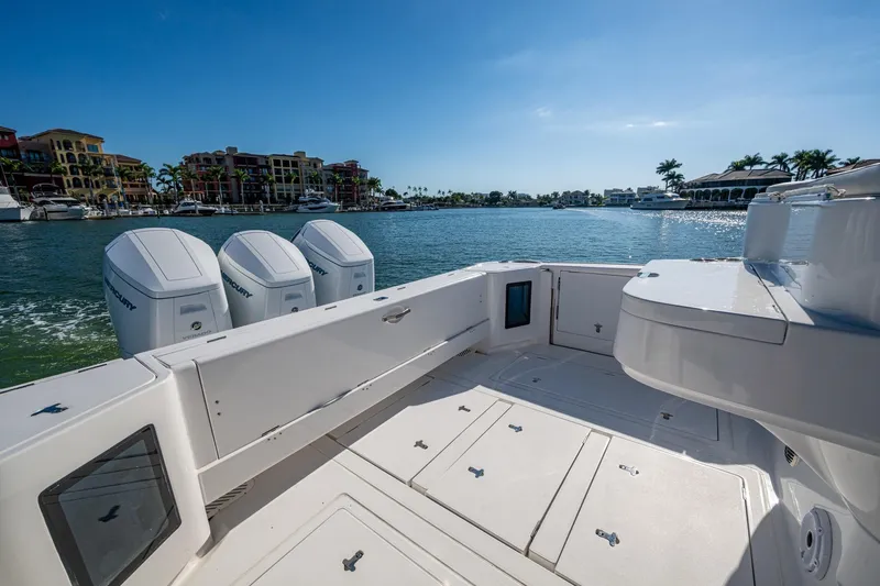 Karey Lee Yacht Photos Pics 2024 Intrepid 477 Evolution boat with triple Mercury engines, docked in a scenic marina.