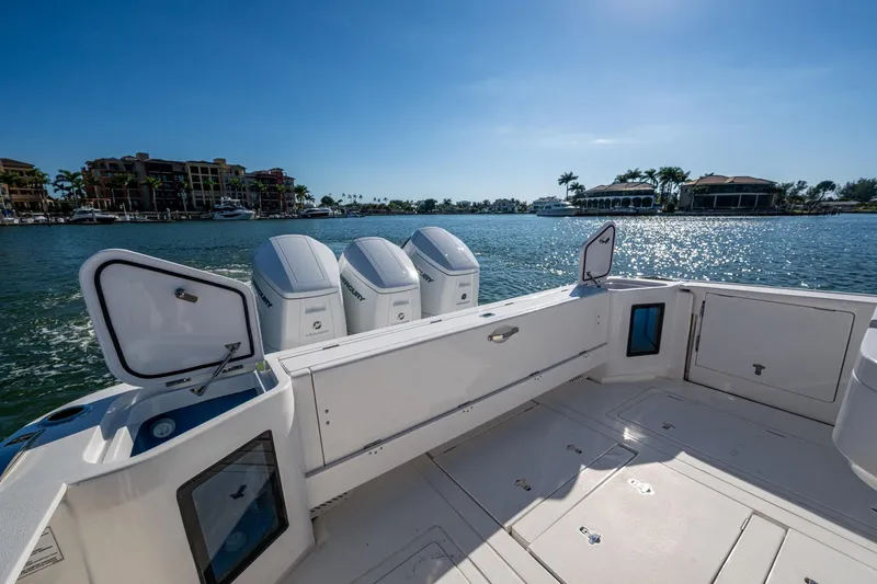 Karey Lee Yacht Photos Pics 2024 Intrepid 477 Evolution boat with open hatches, docked by waterfront homes.