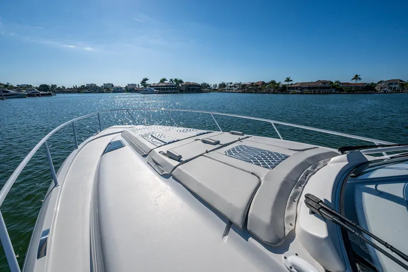 Karey Lee Yacht Photos Pics 2024 Intrepid 477 Evolution yacht cruising on a sunny day, with waterfront homes in the background.