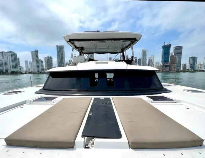 Octopus Yacht Photos Pics 2017 Fountaine Pajot Ipanema 58 Power Catamaran with city skyline in the background.