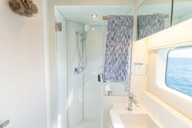  Yacht Photos Pics Modern yacht bathroom with shower, towel, and ocean view. Two Oceans 555 - 008, 2025 model.