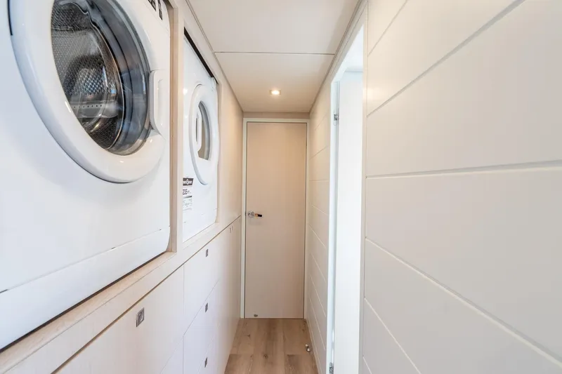  Yacht Photos Pics Laundry area with stacked washers in a modern Two Oceans 555 - 008 yacht, 2025 model.