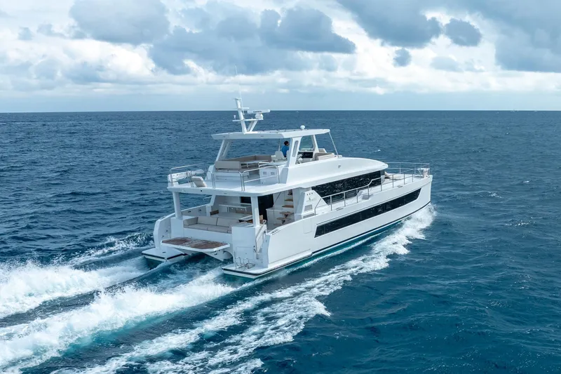  Yacht Photos Pics Luxurious 2025 Two Oceans 555 - 008 yacht cruising on open sea under cloudy skies.