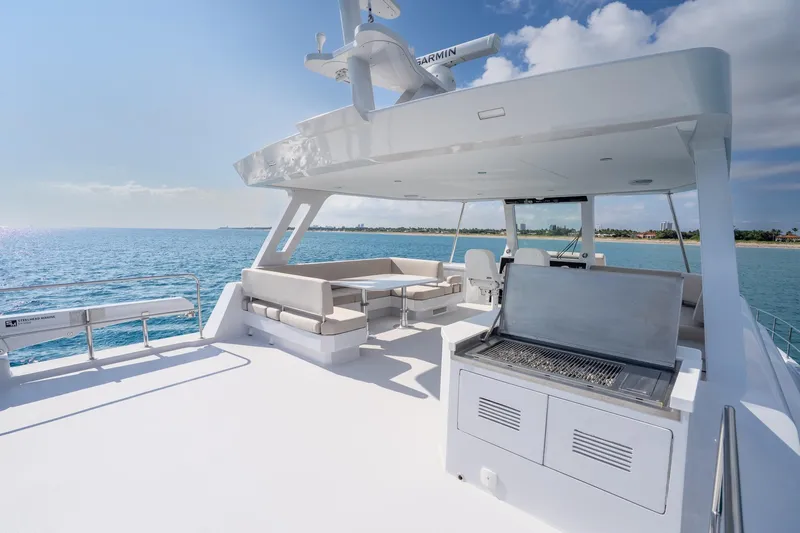  Yacht Photos Pics Luxurious 2025 Two Oceans 555-008 yacht deck with seating and grill, overlooking serene ocean.