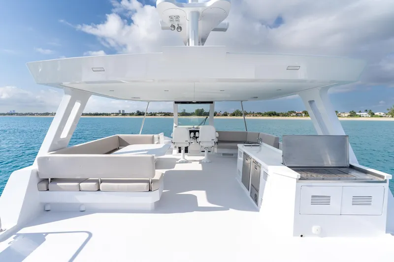  Yacht Photos Pics Luxurious 2025 Two Oceans 555-008 yacht deck with seating and grill, overlooking serene ocean.