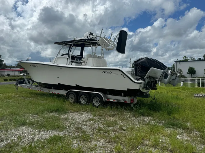  Yacht Photos Pics 2023 Front Runner 36 Center Console boat on trailer, parked on grassy area.