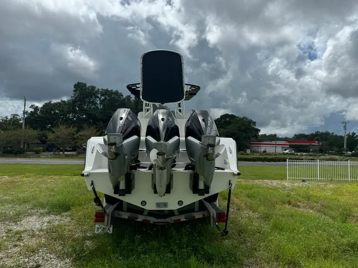  Yacht Photos Pics 2023 Front Runner 36 Center Console boat with triple outboard engines, parked on grass.