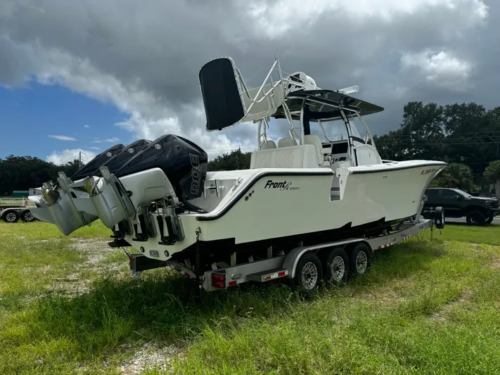  Yacht Photos Pics 2023 Front Runner 36 Center Console boat on trailer, parked on grassy field.