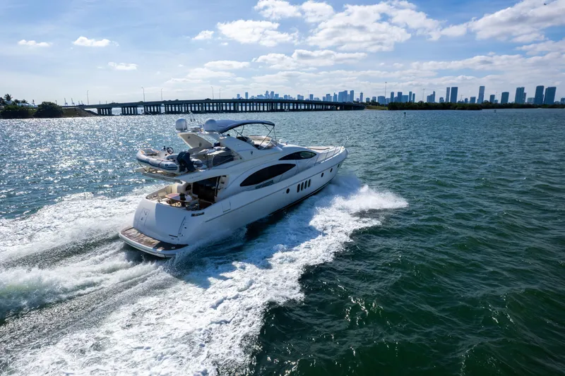 Freedom Yacht Photos Pics Luxurious 2005 Azimut 68 yacht cruising on open water near a city skyline.