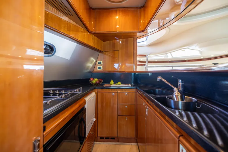 Freedom Yacht Photos Pics Luxurious kitchen interior of 2005 Azimut 68 yacht with wood cabinetry and modern appliances.