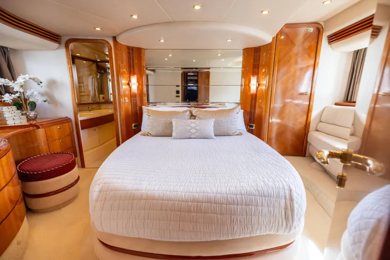 Freedom Yacht Photos Pics Luxurious bedroom interior of 2005 Azimut 68 yacht with elegant wood finishes and plush bedding.