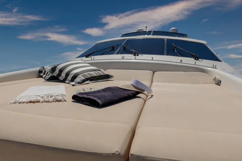  Yacht Photos Pics Luxurious Canados 72s yacht deck with cushions, towels, and a hat under a clear blue sky.