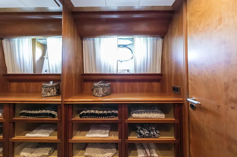  Yacht Photos Pics Luxurious wooden cabinetry in 2004 Canados 72s yacht interior, featuring shelves and window.