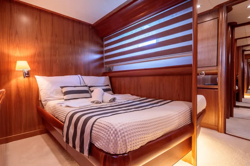  Yacht Photos Pics Luxurious bedroom interior on 2004 Canados 72s yacht with wood paneling and striped bedding.