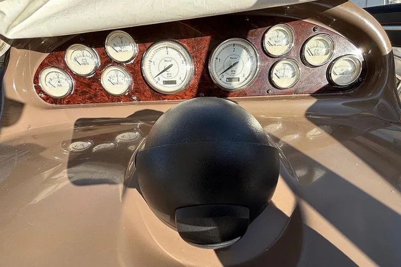  Yacht Photos Pics Dashboard of a 2005 Regal Commodore 4260 boat with gauges and steering wheel.