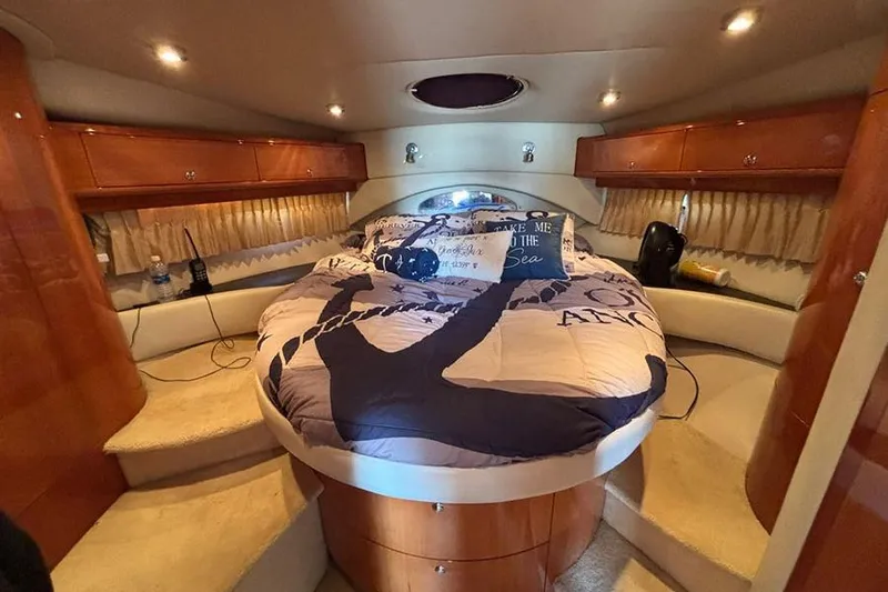  Yacht Photos Pics Luxurious 2005 Regal Commodore 4260 yacht bedroom with cozy bedding and elegant wood cabinetry.