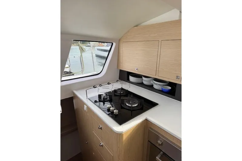 Swell Yacht Photos Pics Modern kitchen interior of 2021 Outremer 51 yacht with stove and cabinets.