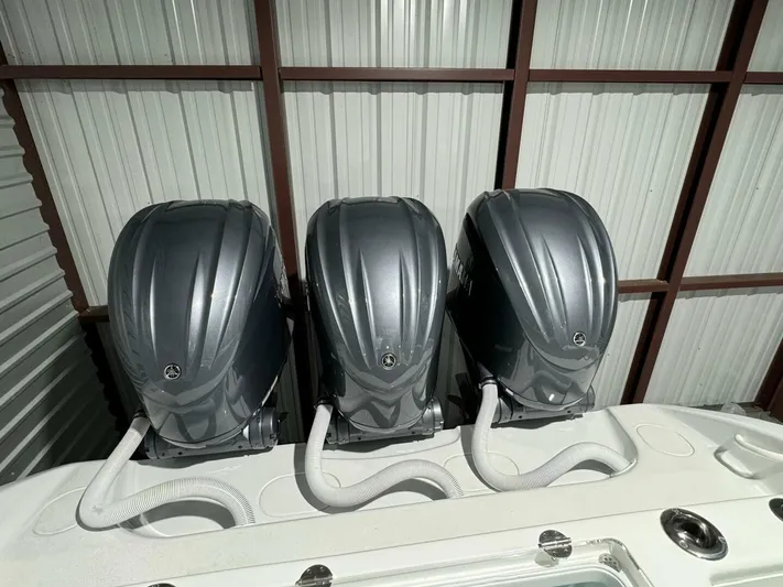 36 Yellowfin Yacht Photos Pics Triple outboard motors on a 2024 Yellowfin 36 boat in a storage facility.
