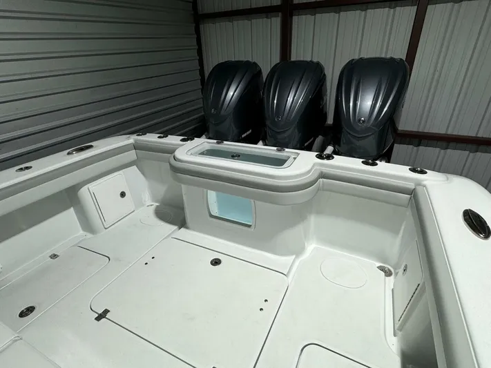 36 Yellowfin Yacht Photos Pics 2024 Yellowfin 36 boat with triple outboard engines in a storage facility.