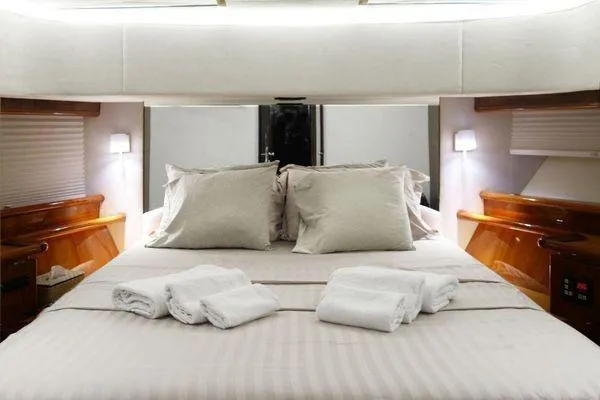 Golden Ex Yacht Photos Pics Luxurious bedroom interior of 2001 Ferretti Yachts 680 with plush bedding and ambient lighting.