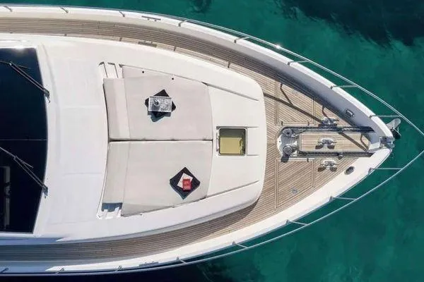 Golden Ex Yacht Photos Pics Aerial view of 2001 Ferretti Yachts 680 deck, featuring sunbathing area and clear turquoise water.