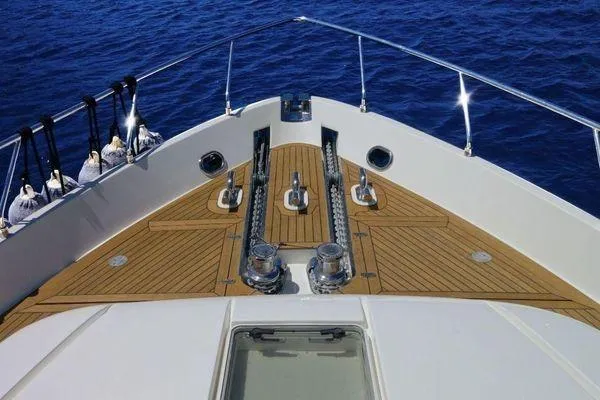 Golden Ex Yacht Photos Pics Bow view of 2001 Ferretti Yachts 680, featuring teak decking and ocean backdrop.