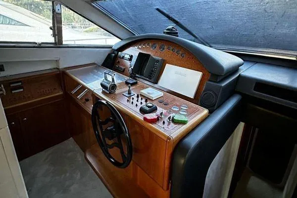 Golden Ex Yacht Photos Pics Cockpit of 2001 Ferretti Yachts 680 with wooden dashboard and steering wheel.