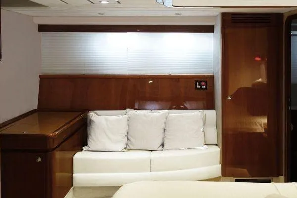 Golden Ex Yacht Photos Pics Interior of 2001 Ferretti Yachts 680 with white sofa and wooden paneling.