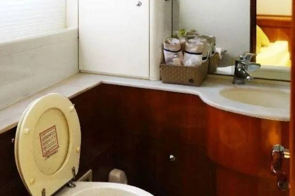 Golden Ex Yacht Photos Pics Luxurious bathroom in 2001 Ferretti Yachts 680, featuring elegant wood cabinetry and modern fixtures.