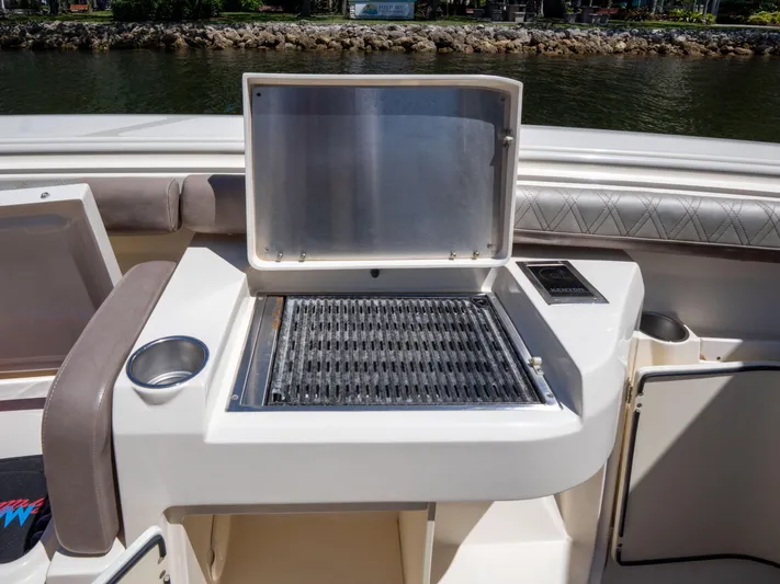  Yacht Photos Pics 2015 Scout 320 LFX boat grill station with open lid, near water.