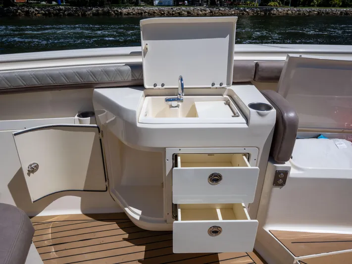  Yacht Photos Pics 2015 Scout 320 LFX boat interior with sink, storage drawers, and open cabinet.