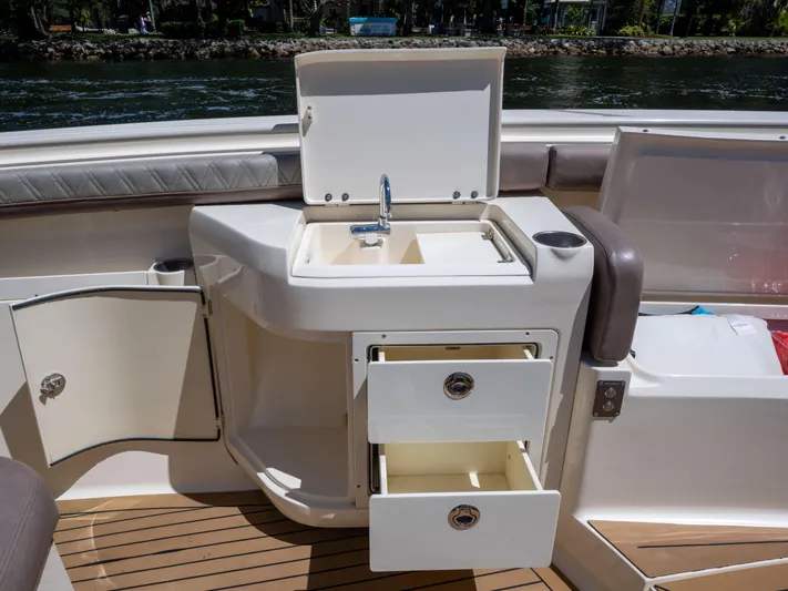  Yacht Photos Pics 2015 Scout 320 LFX boat interior with sink, storage drawers, and open cabinet.