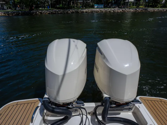  Yacht Photos Pics Twin outboard engines on a 2015 Scout 320 LFX boat, docked on calm water.