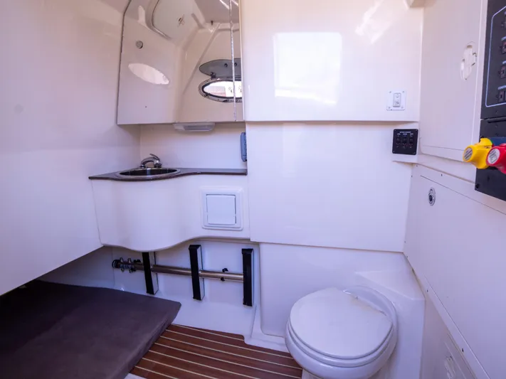  Yacht Photos Pics 2015 Scout 320 LFX boat interior with sink, toilet, and wooden flooring.