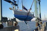 Sailboat "Lucky II" being lifted by crane, Custom Patago 40, 2019 model, at a marina.