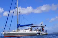 Sailboat "Custom Patago 40" 2019 on calm sea under blue sky with clouds.