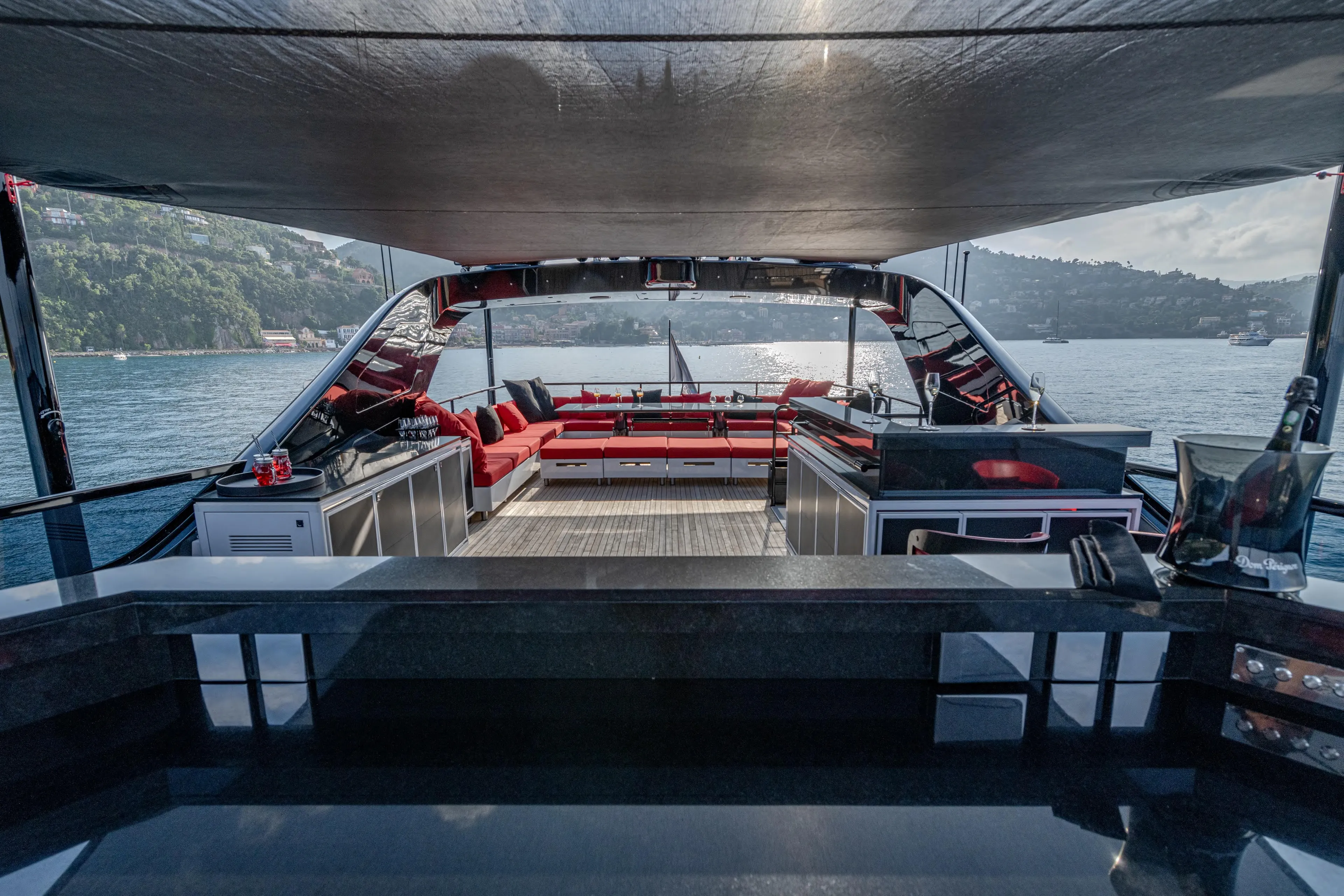 Black Legend Yacht Photos Pics Luxurious 2017 Mangusta 165E yacht interior with red seating, overlooking serene waters.