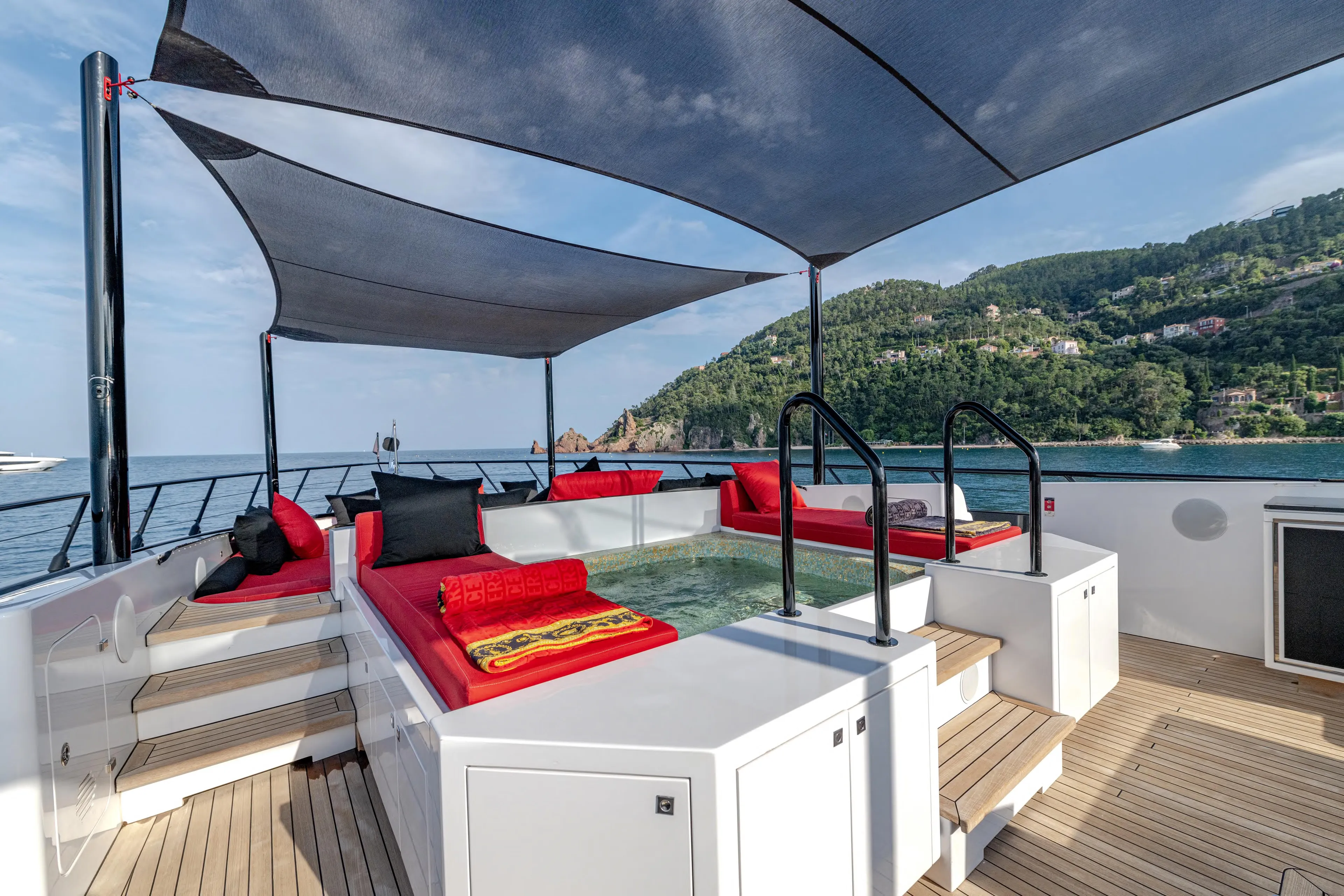 Black Legend Yacht Photos Pics Luxurious 2017 Mangusta 165E yacht deck with red seating and scenic ocean view.