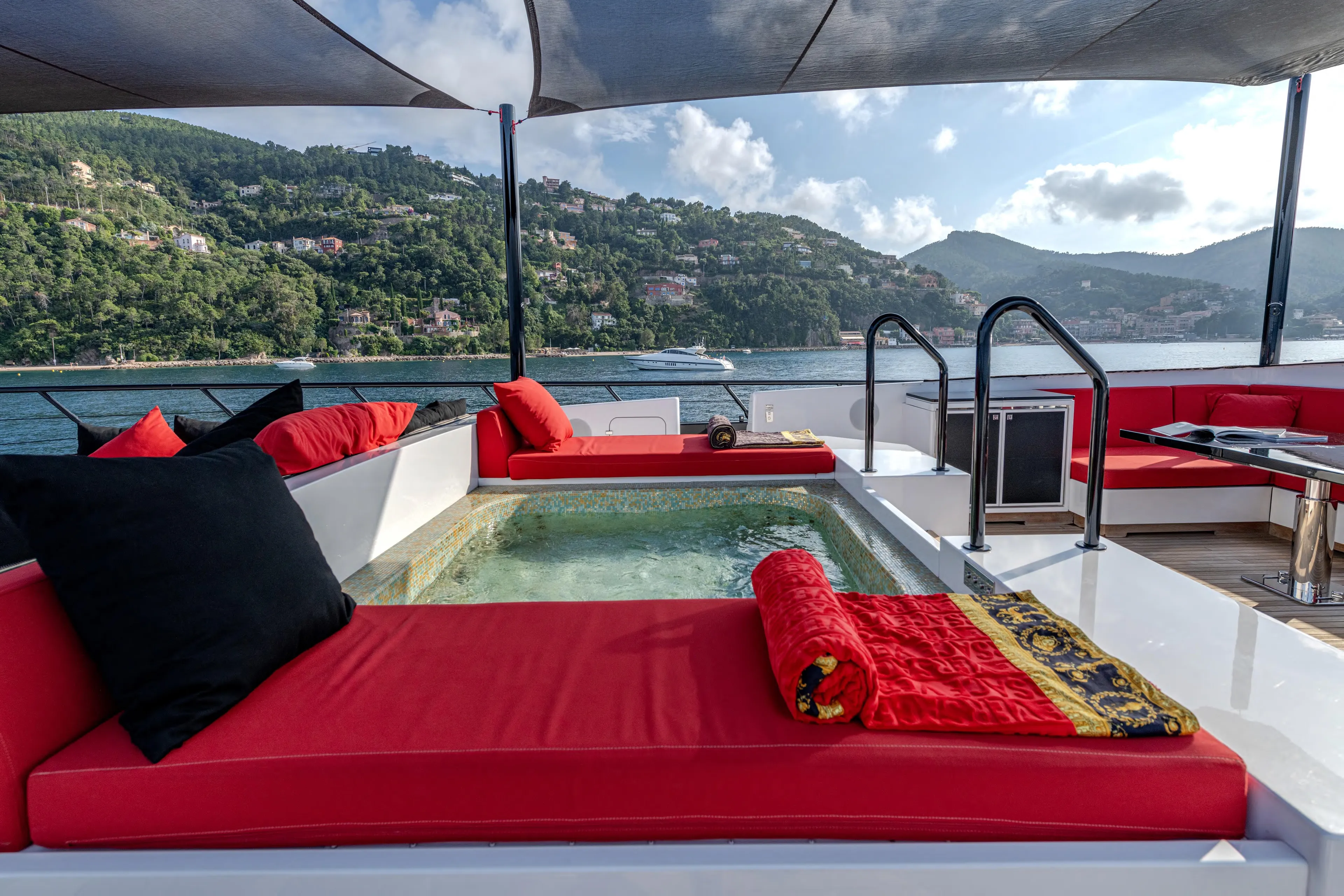 Black Legend Yacht Photos Pics Luxurious 2017 Mangusta 165E yacht deck with red loungers and scenic ocean view.