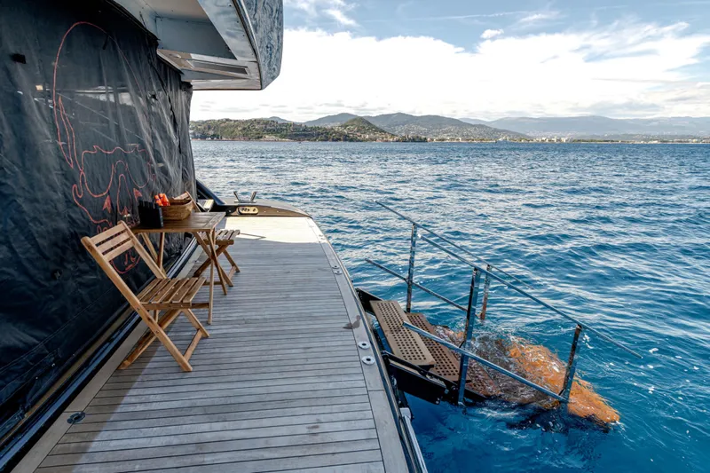 Black Legend Yacht Photos Pics Luxury yacht deck with chairs, table, and ocean view; Mangusta 165E, 2017 model.