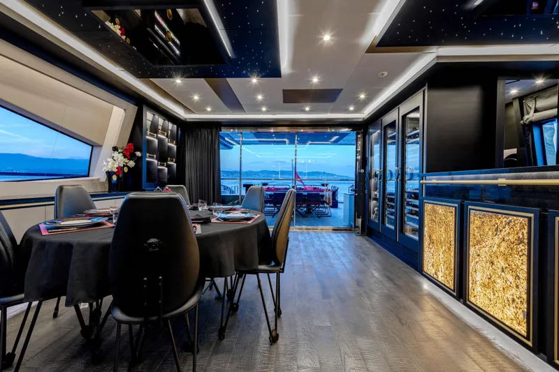 Black Legend Yacht Photos Pics Luxurious interior of 2017 Mangusta 165E yacht with elegant dining area and scenic ocean view.