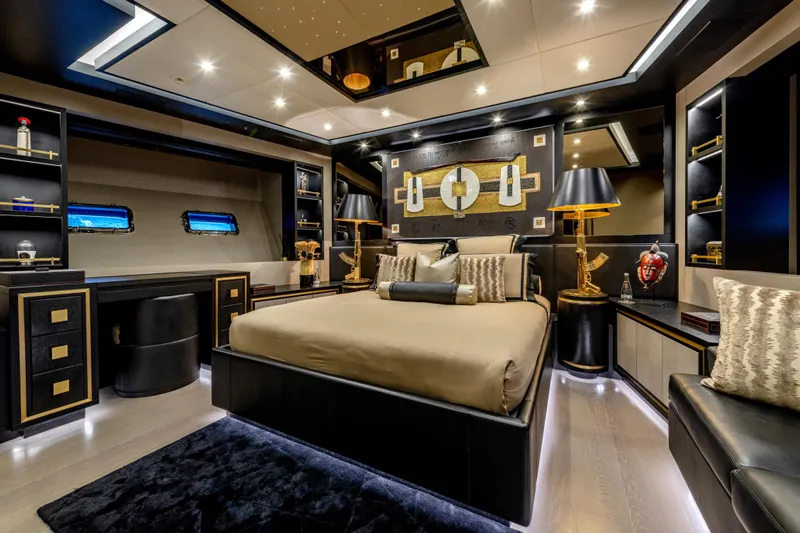 Black Legend Yacht Photos Pics Luxurious bedroom interior of 2017 Mangusta 165E yacht with elegant decor and ambient lighting.