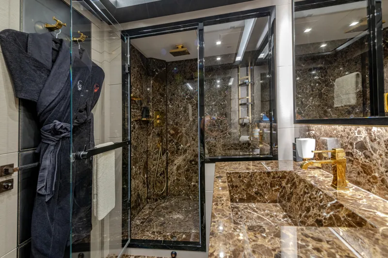 Black Legend Yacht Photos Pics Luxurious marble bathroom in 2017 Mangusta 165E yacht with gold fixtures and glass shower.