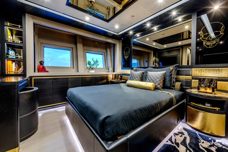 Black Legend Yacht Photos Pics Luxurious bedroom interior on 2017 Mangusta 165E yacht, featuring elegant black and gold decor.