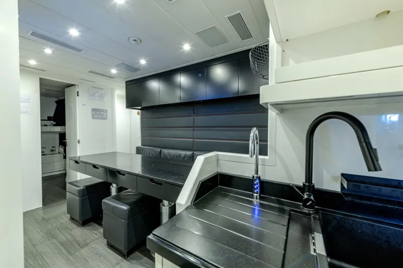 Black Legend Yacht Photos Pics Luxurious interior of 2017 Mangusta 165E yacht with modern kitchen and seating area.