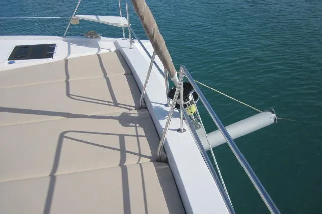  Yacht Photos Pics Bali 4.3 catamaran deck, 2020 model, with beige sunbathing area and railing, on calm water.