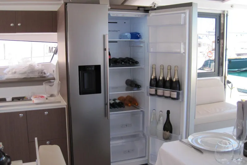  Yacht Photos Pics Open refrigerator on Bali 4.3 yacht, stocked with wine and champagne bottles, modern interior.