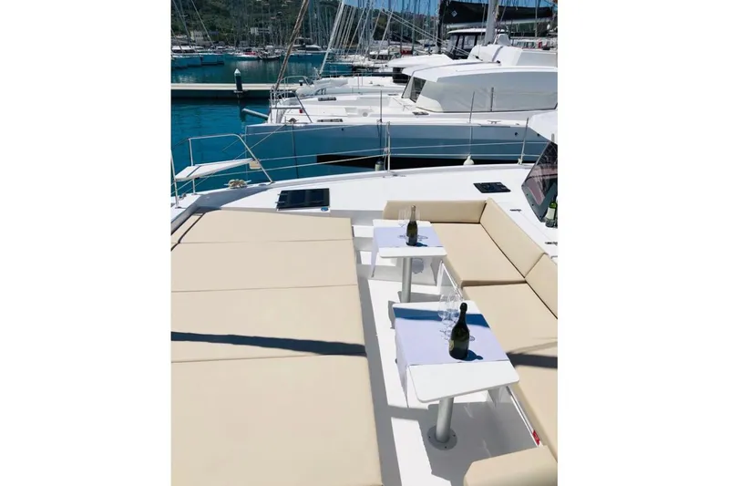  Yacht Photos Pics Luxurious 2020 Bali 4.3 catamaran with sunbathing area and tables, docked at marina.