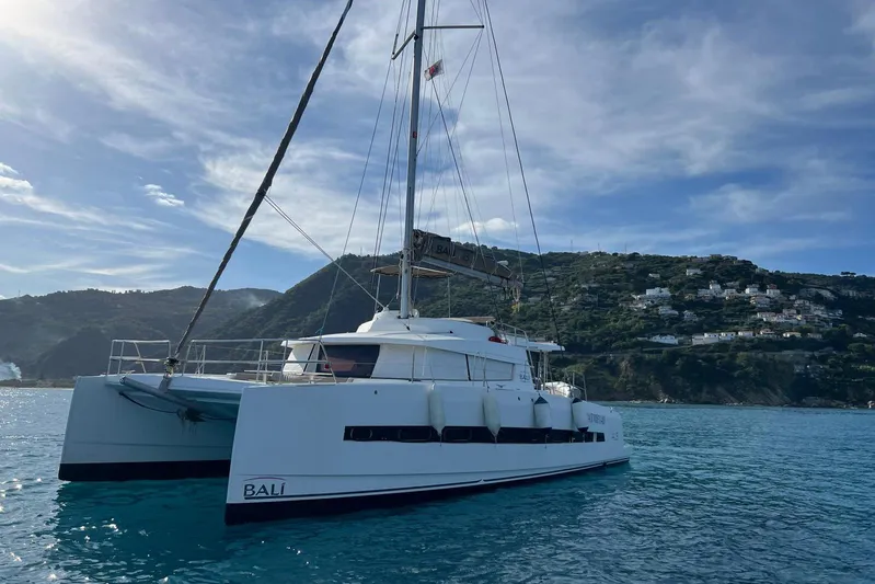  Yacht Photos Pics 2020 Bali 4.3 catamaran sailing near scenic coastal hills under a clear blue sky.